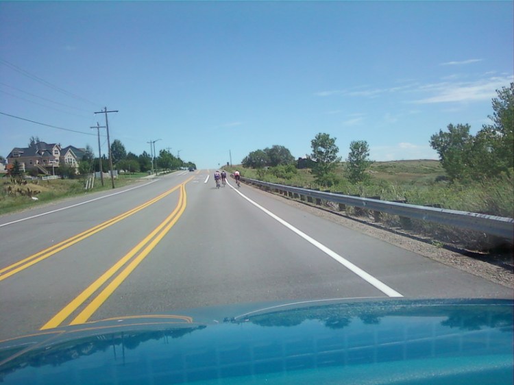 Photo taken from my teal pickup of bicyclists riding their bikes in the auto lane instead of the designated bike lane