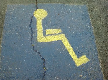 Photo of a handicap parking space where they forgot to paint a wheelchair under the person