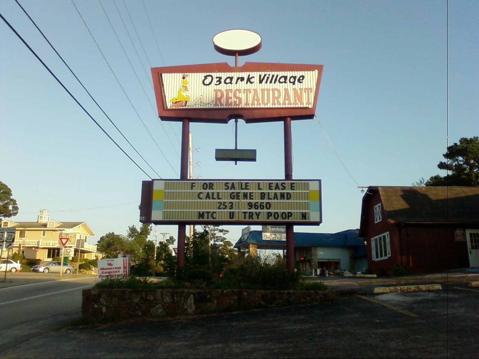 Photo of a sign for Ozark Village Restaurant that has some missing letters and part of the message appears to read "U Try Poop"