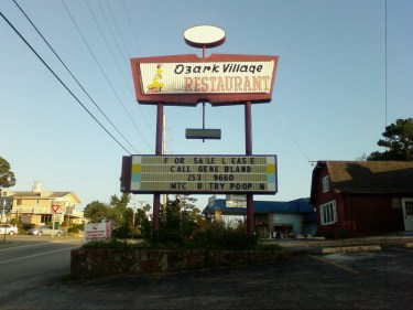 Photo of a sign for Ozark Village Restaurant that has some missing letters and part of the message appears to read "U Try Poop"